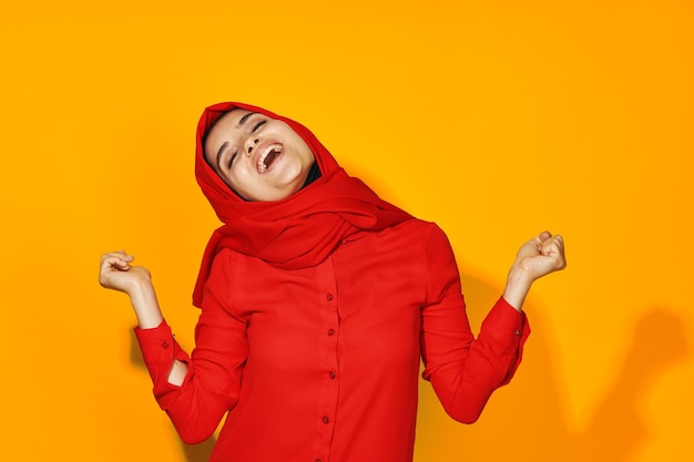 Young woman standing against yellow background